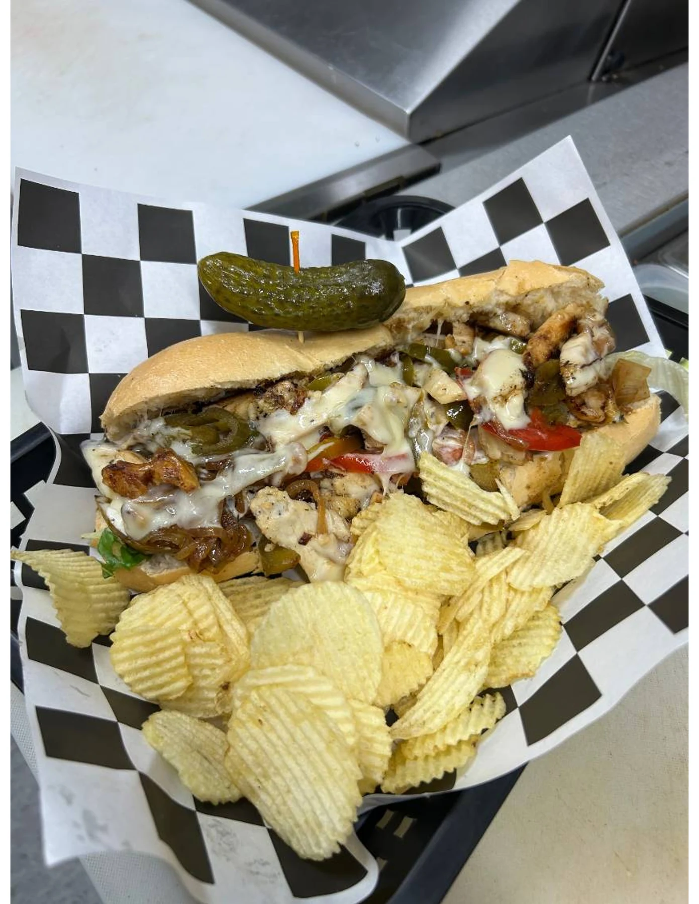 Grilled sandwich with peppers, onions, and melted cheese at Dewberry Kitchen & Tap