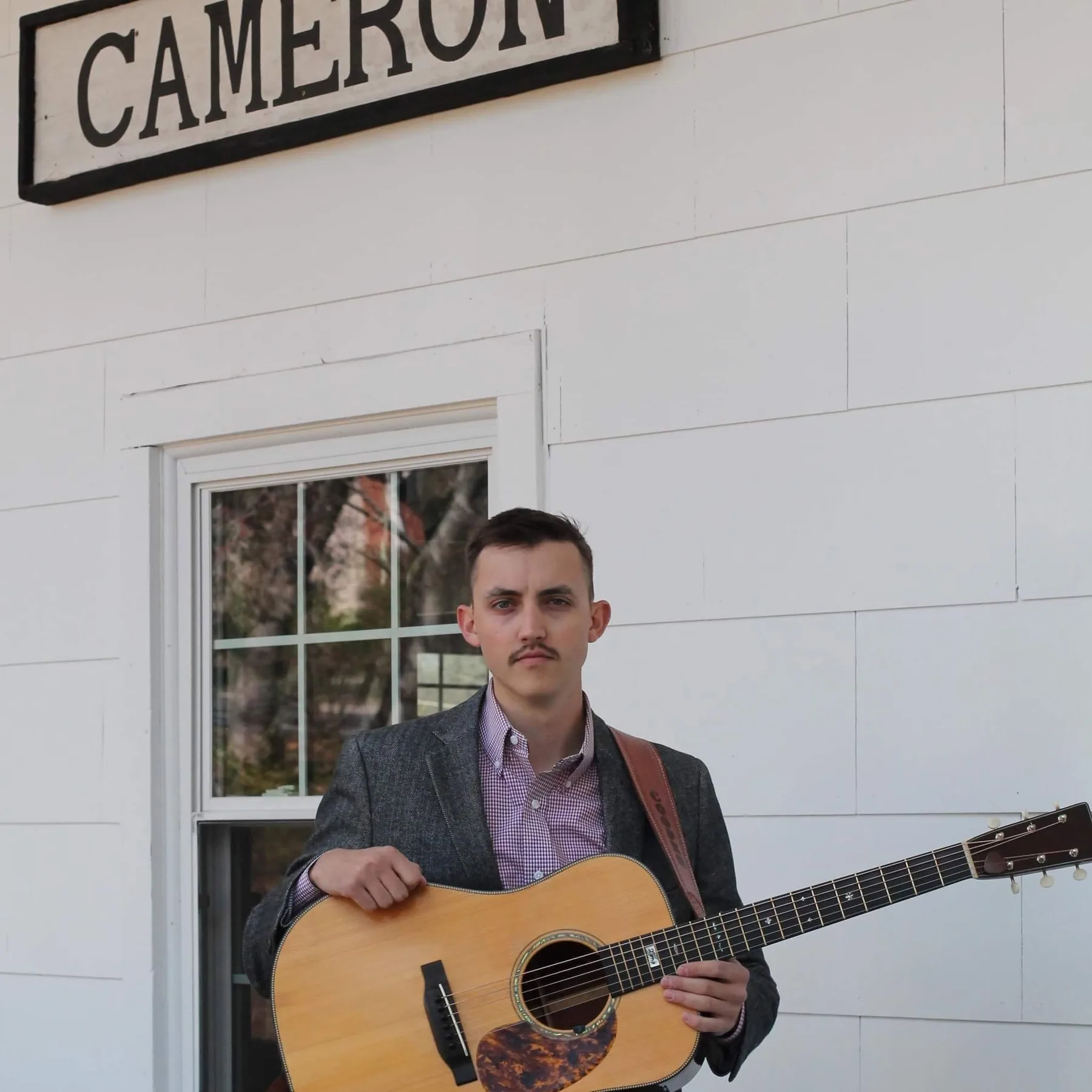 Live music performer in front of Cameron NC sign — Dewberry Kitchen & Tap Friday nights